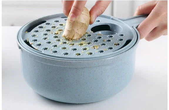 Hands grating fresh ginger on a blue plastic ginger grater bowl in a kitchen setting