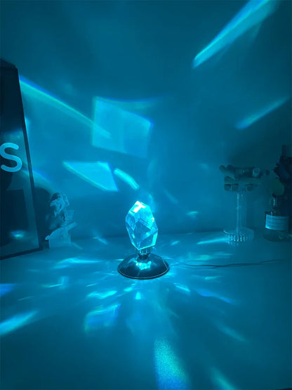 Blue crystal prism lamp on desk casting bright blue light patterns on wall and surface at night