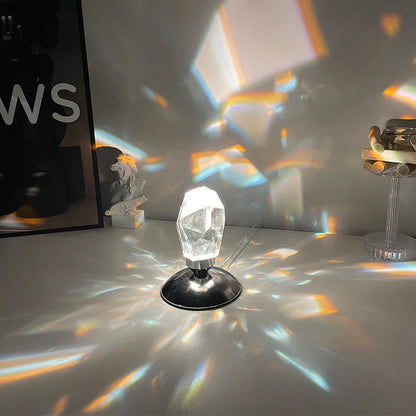 Crystal prism lamp on a table casting colorful light reflections on surrounding surfaces