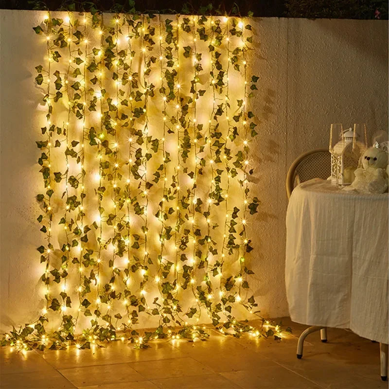 Warm white fairy lights with green ivy leaves hanging on wall, cozy outdoor patio decoration