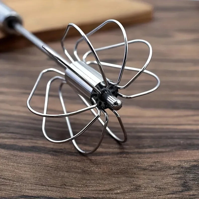 Close-up of stainless steel mixer whisk attachment on wooden surface
