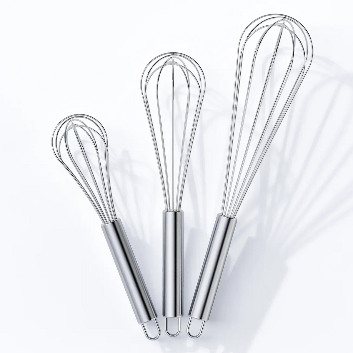 Set of three stainless steel kitchen whisks in small, medium, and large sizes on white background