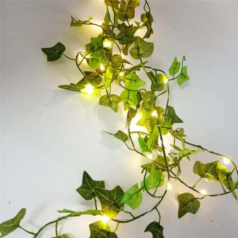 Green artificial ivy garland with warm LED fairy lights on white background
