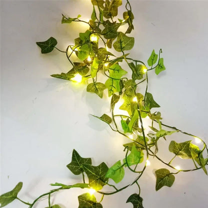 Green artificial ivy garland with warm LED fairy lights on white background