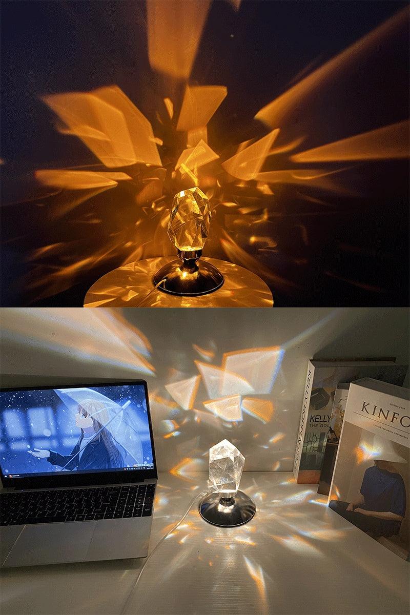Crystal prism lamp casting colorful light patterns on wall and desk near laptop and books